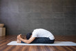 Experienced yogi doing seated forward bend yoga pose in gym. Man practicing yoga. Yogi concept. Side view.