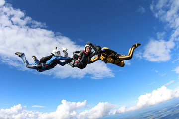 Wall Mural - Skydiving. Two instructors are training a student to fly.