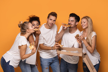 Multiracial people having fun, eating pizza.