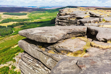 Wall Mural - Peak District National Park, Derbyshire, England. Rock formations, stacked stones in Stanage edge, with the fields and pastures on the background, selective focus