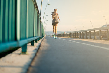 Wall Mural - Young woman jogging in the afternoon