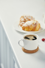 Wall Mural - close up view of cup of aromatic coffee and croissants for breakfast on white surface