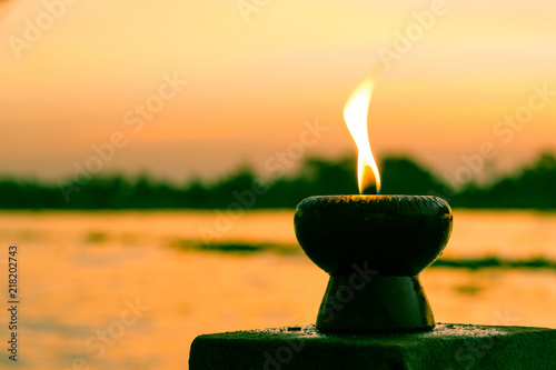 Fotografía Candle light fire lamp nearby abstract background river during sunset or sunrise in countryside
