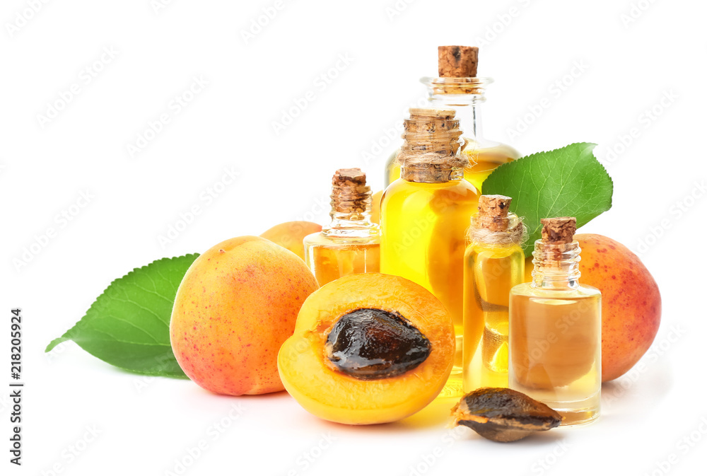Bottles of apricot essential oil on white background