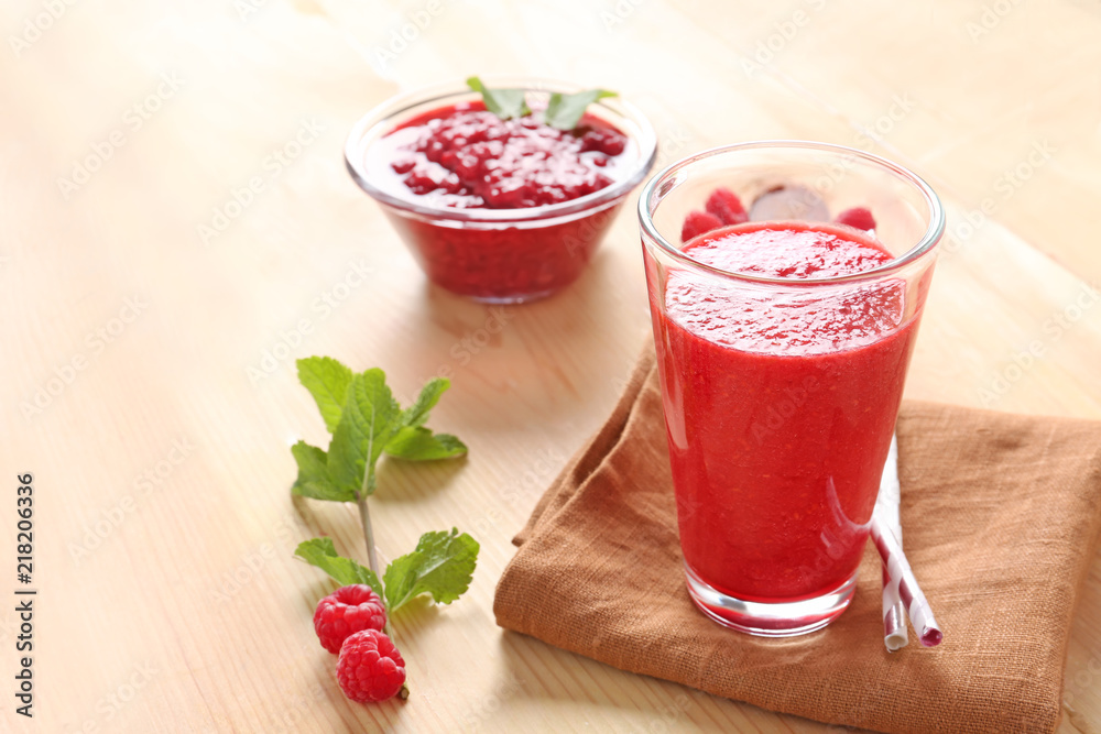 Glass of tasty raspberry smoothie on table