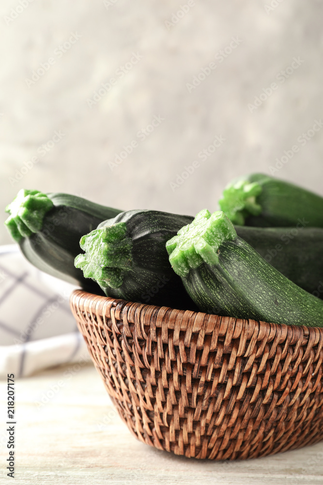 Basket with ripe zucchinis on wooden table