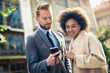 © Mediteraneo - Happy business couple using smart phone outdoors