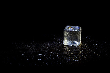 ice cubes reflection on black table background.