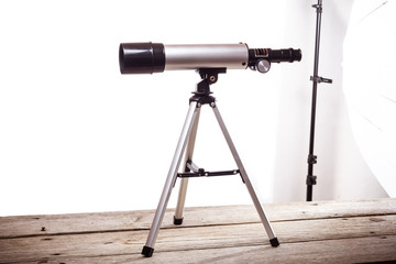 Wall Mural - telescope on a white background laid on wooden board