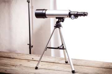 Wall Mural - telescope on a white background laid on wooden board