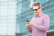 © zphoto83 - Portrait of fashionable businessman using smartphone outdoors.