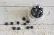 Yogurt with bluberries and oats, top view. Overnight oats in a glass jar on wooden table. Healthy ans easy breakfast recipe