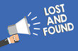 Text sign showing Lost And Found. Conceptual photo Place where you can find forgotten things Search service Man holding megaphone loudspeaker blue background message speaking loud.
