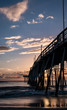 © Seth Michael - Amazing morning sky lights up an ocean pier. Beautiful tones of many colors on the horizon. Sunlight reflected on the surface of the ocean. Vertical image.