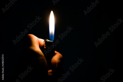 Fotomural Burning lighter in the hand in the dark