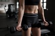 © Wavebreak Media - Midsection of women exercising with dumbbell in gym