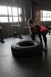 © Wavebreak Media - Woman exercising with tyre in fitness studio