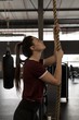 © Wavebreak Media - Woman doing rope climbing exercise in fitness gym