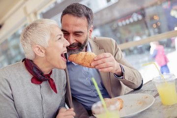 Wall Mural - Happy mature couple having breakfast in cafe