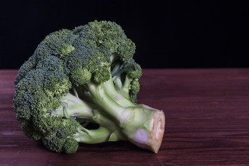 green broccoli on a wooden table. concept: healthy eating, vegetarianism, raw food