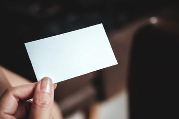 Closeup image of a hand holding empty business card in office