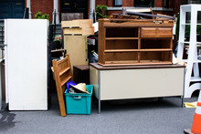 Items And Old Furniture On Street Outside House Moving Day Or Getting Rid Of Junk Concept