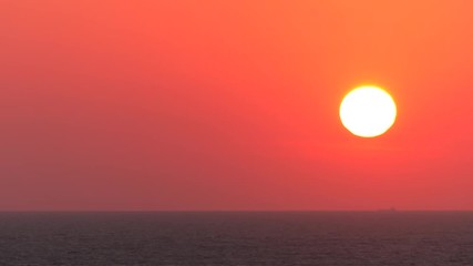 Wall Mural - Red sunset. The sun touches the horizon. Calm sea. Small waves.  Panning,Closeup, 