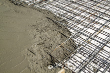 Pouring Concrete Into Prepared Place With Reinforced Metal Frame