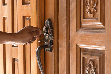 Wall Mural - Men are unlocking the door. Wooden door of Thai style wooden house.