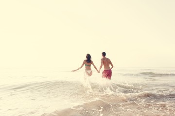 Wall Mural - Happy couple running into the water