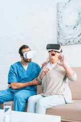 young social worker and excited senior woman using virtual reality headsets