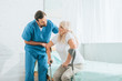 © LIGHTFIELD STUDIOS - male social worker helping sick senior woman with crutches