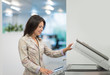 © Mak - Young businesswoman using photocopy machine in office