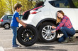 © Sergey Novikov - Little boy helping his mother to change flat tyre