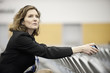 © Mint Images - A businesswoman sitting alone in a room full of chairs prior to a meeting in a conference centre.