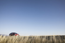A Red Sedan Parked Along A Highway In Eastern Washington State, USA.