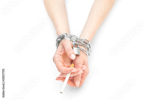 Fotografia Woman's hands tied by chain with cigarette on white.