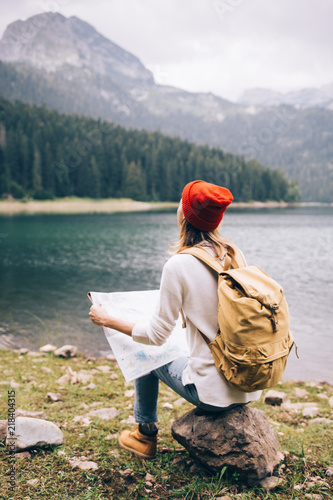 Fotografia Woman traveler with backpack checks map