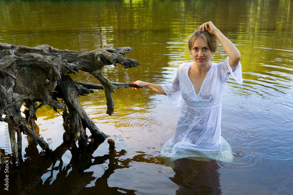 Beautiful girl in a wet translucent white dress in the water. Stock Photo | Adobe Stock Beautiful girl in a wet translucent white dress in the water. Stock Photo | Adobe Stock