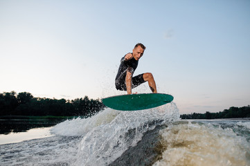 Wall Mural - Wakesurfer riding down the river on a blue board