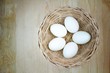 © Alongkorn - 5 eggs in rattan basket on wooden background, lighten center