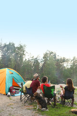 people resting near camping tent in wilderness