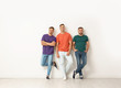 © New Africa - Group of young men in jeans and colorful t-shirts near light wall