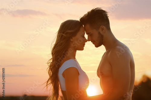 Fotografía Happy young couple in beachwear outdoors at sunset