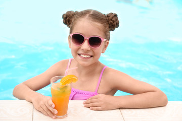 Poster - Little girl with cocktail in pool on sunny day