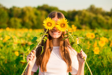 Happy Joyful Girl With Sunflower Enjoying Nature And Laughing On Summer Sunflower Field 