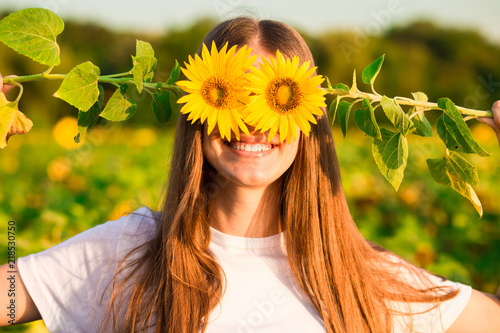 Happy joyful girl with sunflower enjoying nature and laughing on summer sunflowe Fototapete