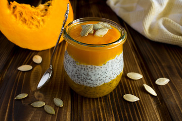 Wall Mural - Pudding with chia and  pumpkin  on the brown wooden background