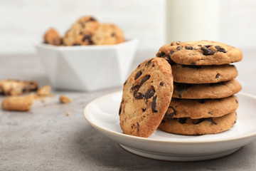 Plate with tasty chocolate cookies on gray table