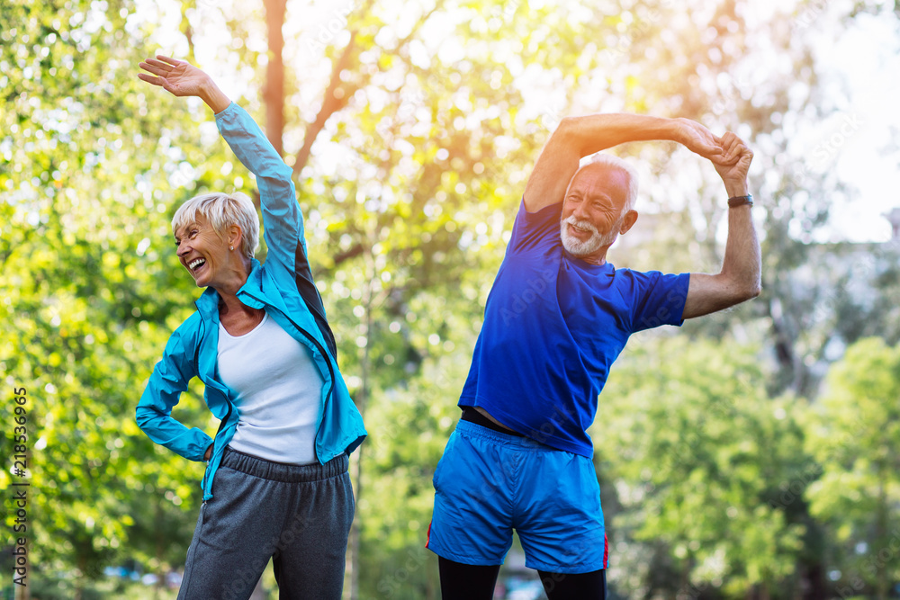 Happy fit senior couple exercising in park. - obrazy, fototapety, plakaty 